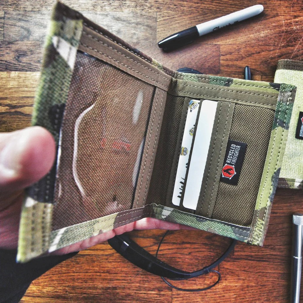 "The Captain" by Recycled Firefighter is a rugged bifold wallet handcrafted from decommissioned fire hose for maximum durability. Its slim, wide-profile design features a clear ID window and is built to lay flat in your pocket.