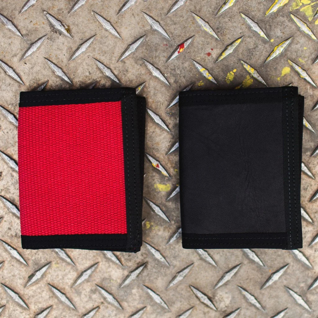 "The Captain" by Recycled Firefighter is a rugged bifold wallet handcrafted from decommissioned fire hose for maximum durability. Its slim, wide-profile design features a clear ID window and is built to lay flat in your pocket.