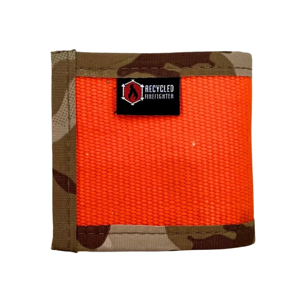 This durable Fire Hose Drink Sleeve from Recycled Firefighter features a rugged orange exterior paired with a tan "Arid" desert-camo-inspired lining. Handcrafted from authentic decommissioned fire hose, this variant showcases unique scuff marks and a patriotic, tactical aesthetic.