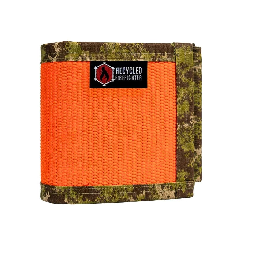 The Recycled Firefighter Fire Hose Drink Sleeve is shown in the Orange and Green Digital Woodland variant, featuring a rugged camouflage pattern with vibrant orange accents. Handcrafted from decommissioned fire hose, this durable insulator provides a tactical look and a non-slip grip for your beverage.