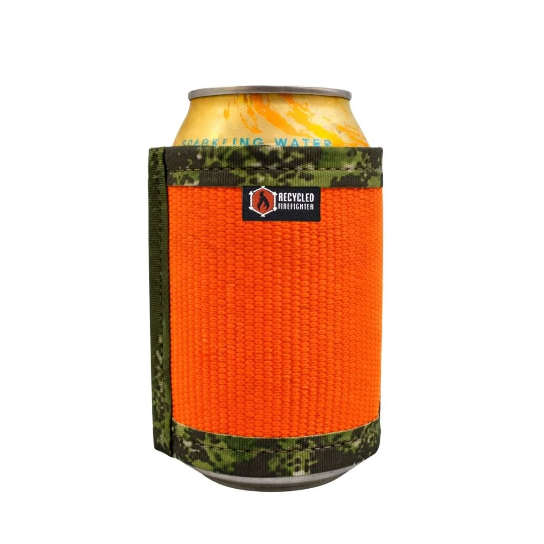 The Recycled Firefighter Fire Hose Drink Sleeve is shown in the Orange and Green Digital Woodland variant, featuring a rugged camouflage pattern with vibrant orange accents. Handcrafted from decommissioned fire hose, this durable insulator provides a tactical look and a non-slip grip for your beverage.