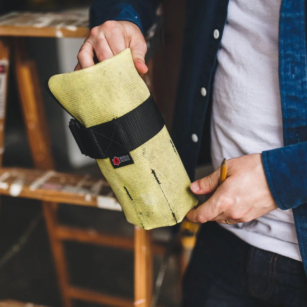 Vintage Yellow Fire Hose Tool Roll from Recycled Firefighter, showcasing the unique scuffs and character of real retired fire gear. This heavy-duty roll is box-stitched at all stress points to ensure a lifetime of reliable tool storage.