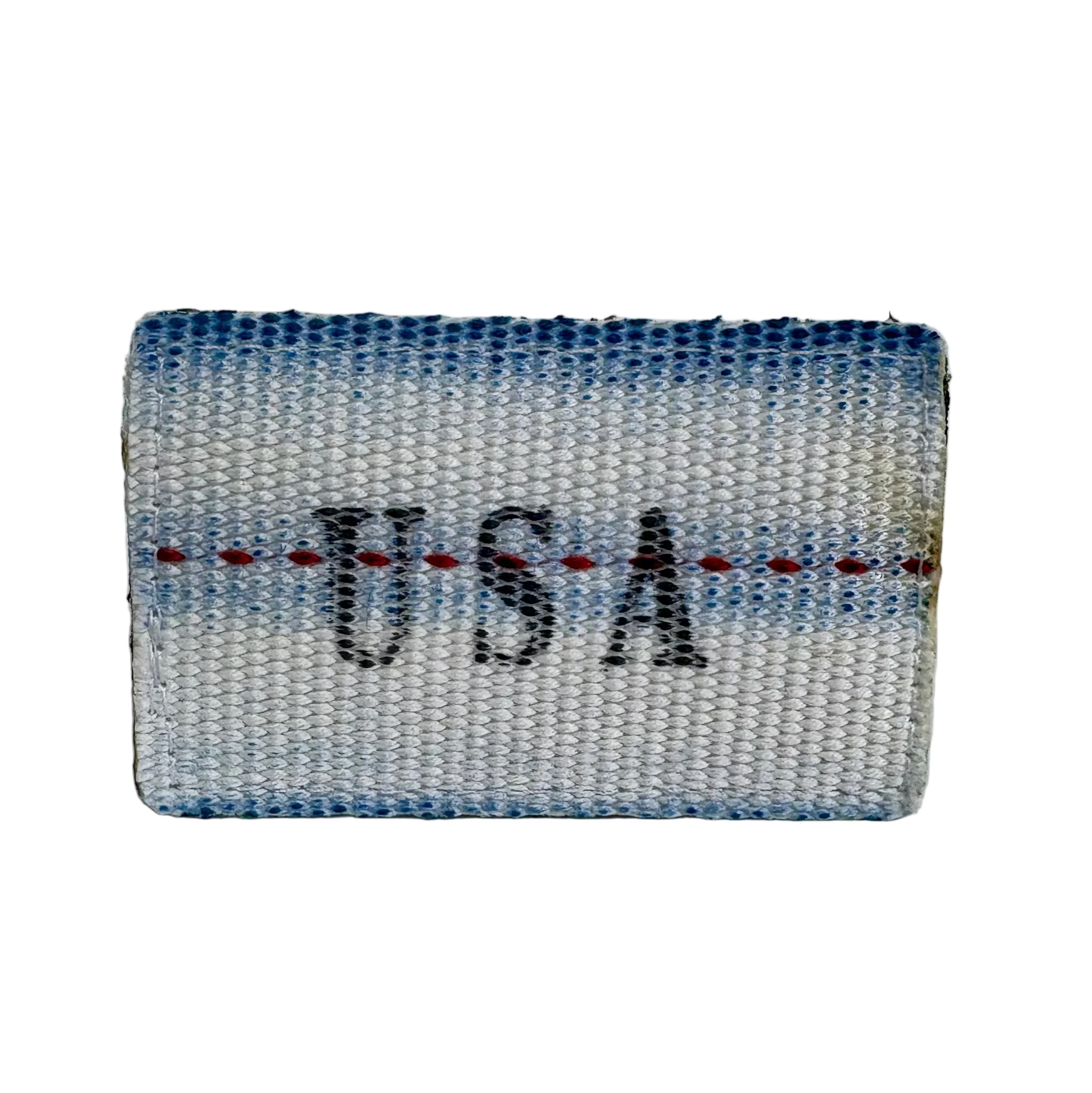 Firehose Patch detail view — reclaimed fire hose material with stitched Recycled Firefighter branding, hook-and-loop back.