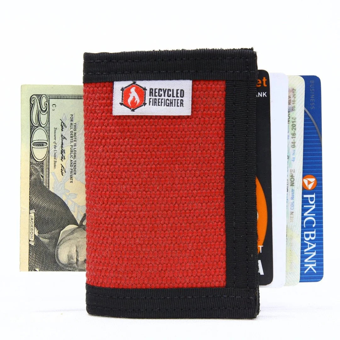The Rookie minimalist bifold wallet by Recycled Firefighter, handcrafted from repurposed orange fire hose with green digital camo trim and an integrated elastic cash strap.