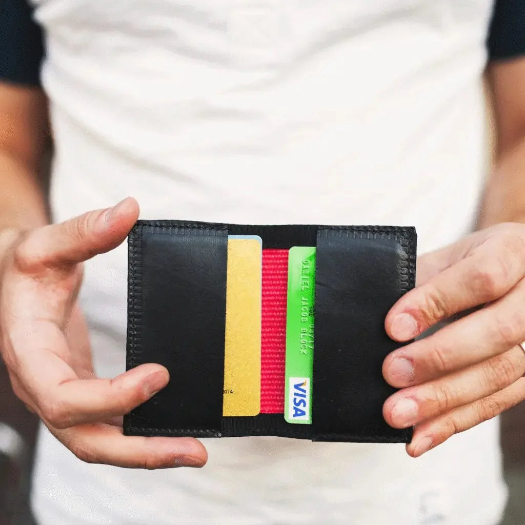 The Rookie minimalist bifold wallet by Recycled Firefighter, handcrafted from repurposed orange fire hose with green digital camo trim and an integrated elastic cash strap.