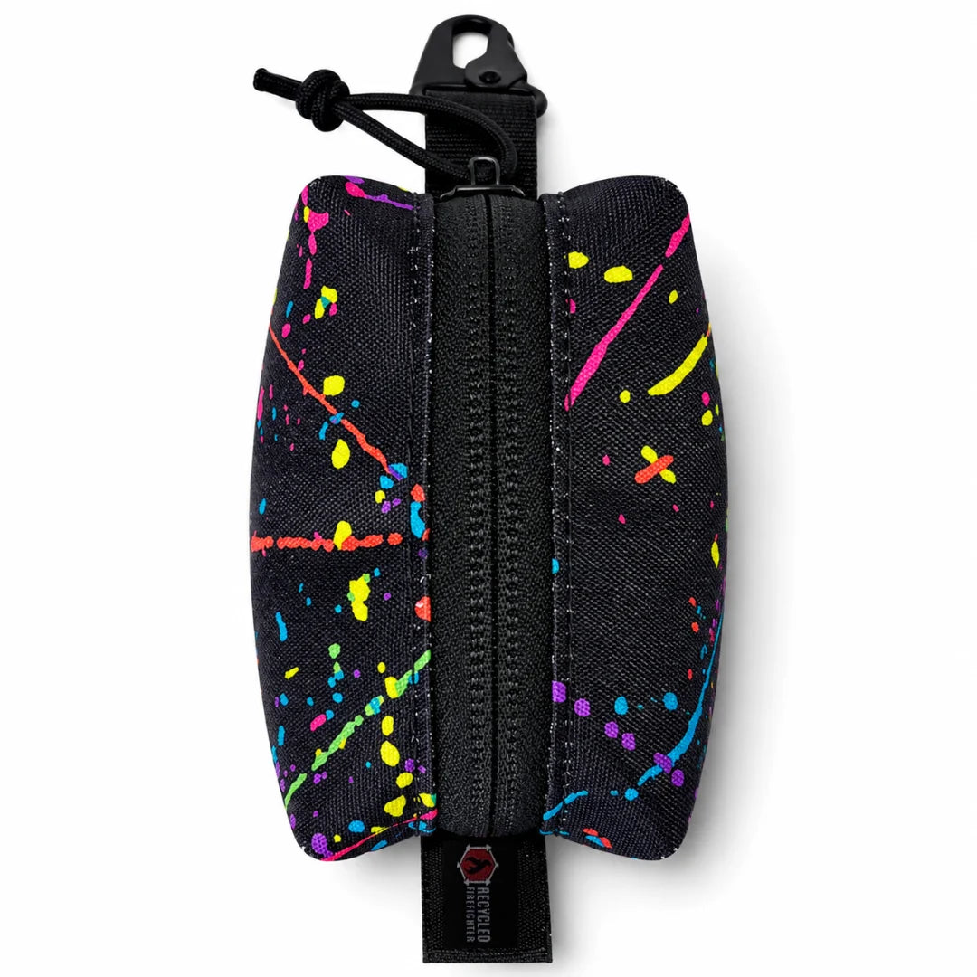The Splatter variant of Recycled Firefighter's Hot Shot Commander Keychain Pouch brings bold, paint-splatter styling to a USA-made EDC keychain organizer built for everyday carry. A heavy-duty zipper and strong metal clip keep your small essentials secured and accessible.