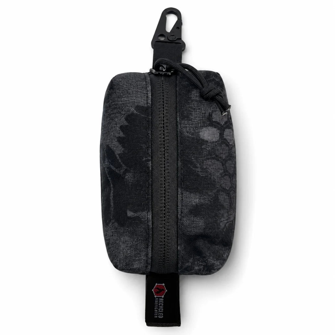 The Typhon-pattern Hot Shot Commander Keychain Pouch from Recycled Firefighter delivers a dark, shadow-camo EDC organizer built for low-profile tactical carry. Featuring a secure zip closure and metal clip, this USA-made keychain pouch handles high-intensity movement with ease.