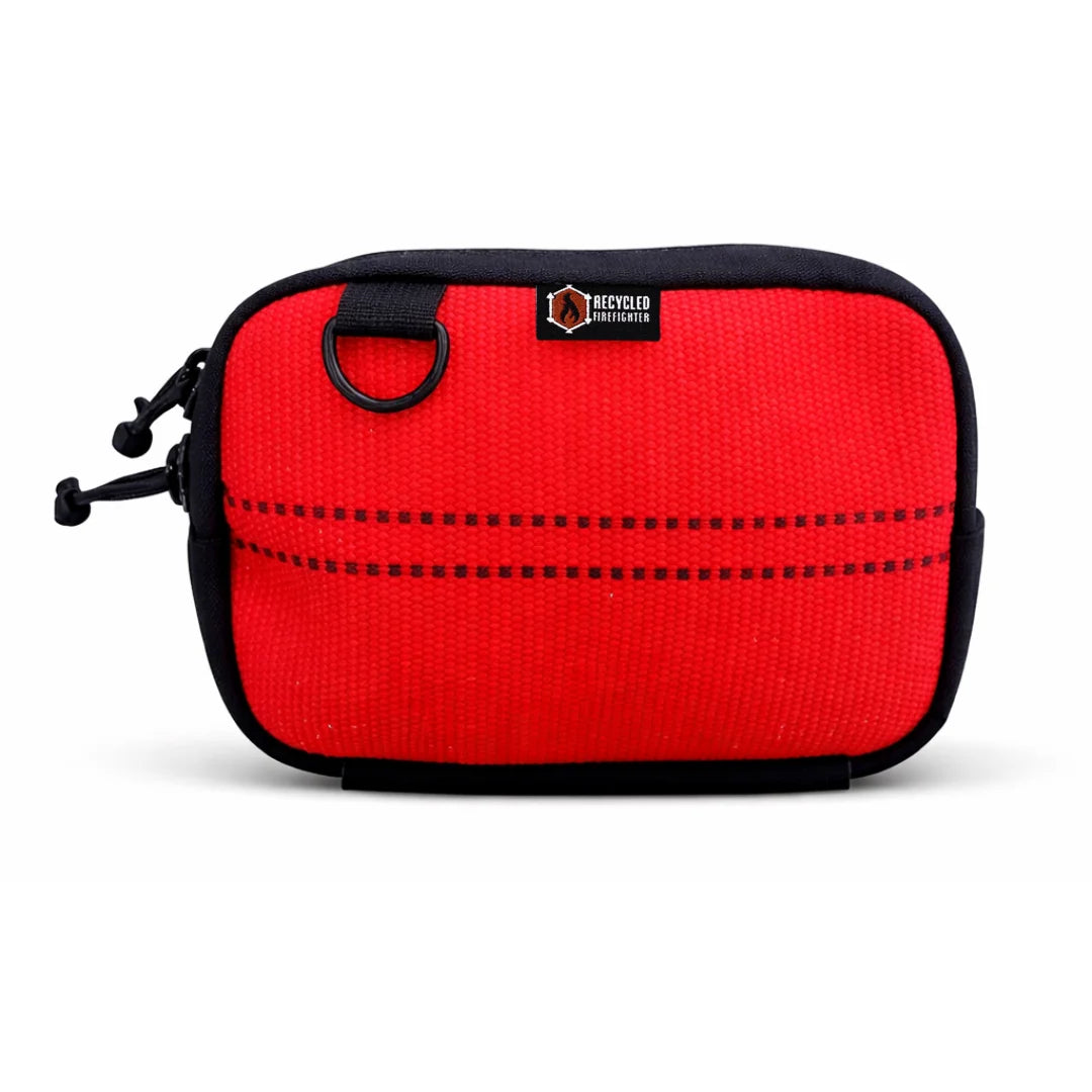 The Recycled Firefighter Trailhound pack in Ocean Breeze firehose, featuring a bright turquoise or teal hue. The rugged upcycled fabric is accented with black zippers and a bottom elastic pouch for securing extra gear.