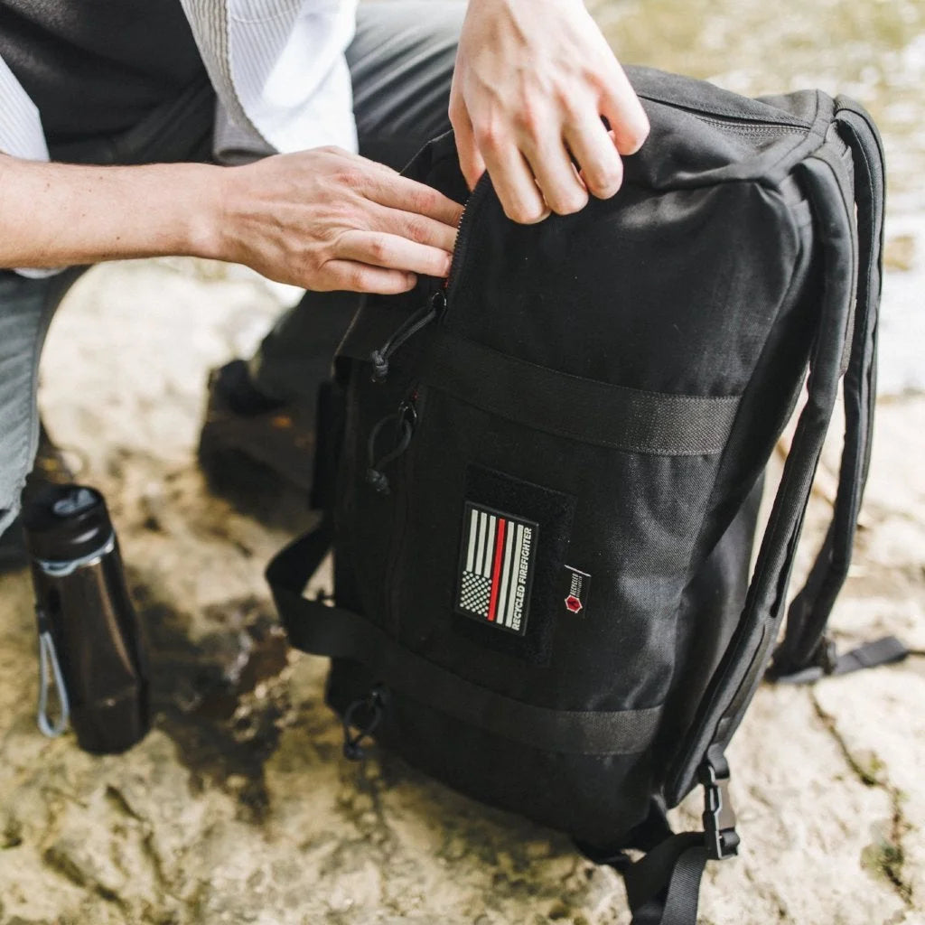 A rugged black Recycled Firefighter 72 Hour Duffle Backpack featuring heavy-duty straps and a vertical zipper for easy access.