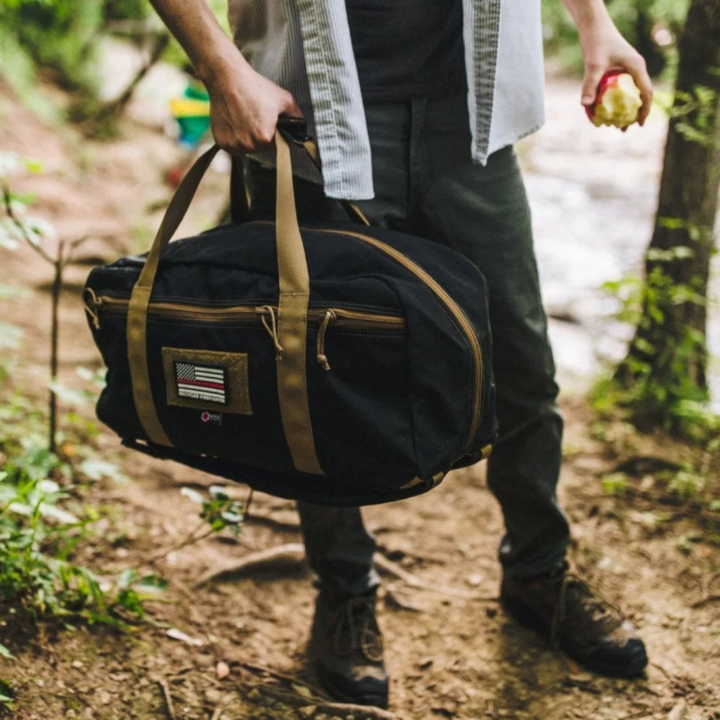 This Recycled Firefighter 72 Hour Duffle Backpack features a two-tone black and coyote brown design for a high-contrast tactical appearance.
