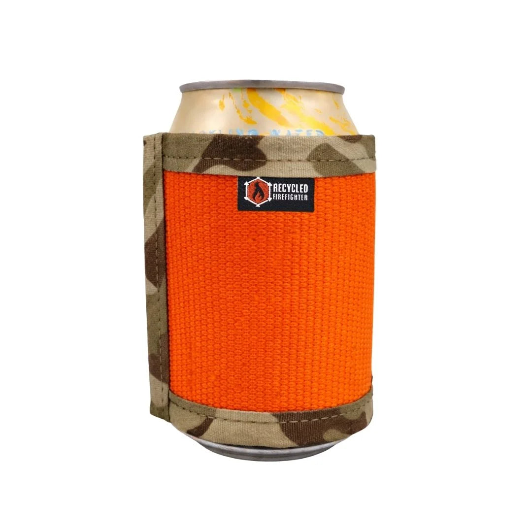 This durable Fire Hose Drink Sleeve from Recycled Firefighter features a rugged orange exterior paired with a tan "Arid" desert-camo-inspired lining. Handcrafted from authentic decommissioned fire hose, this variant showcases unique scuff marks and a patriotic, tactical aesthetic.