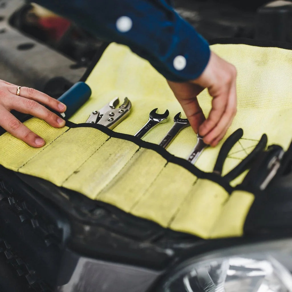 Vintage Yellow Fire Hose Tool Roll from Recycled Firefighter, showcasing the unique scuffs and character of real retired fire gear. This heavy-duty roll is box-stitched at all stress points to ensure a lifetime of reliable tool storage.