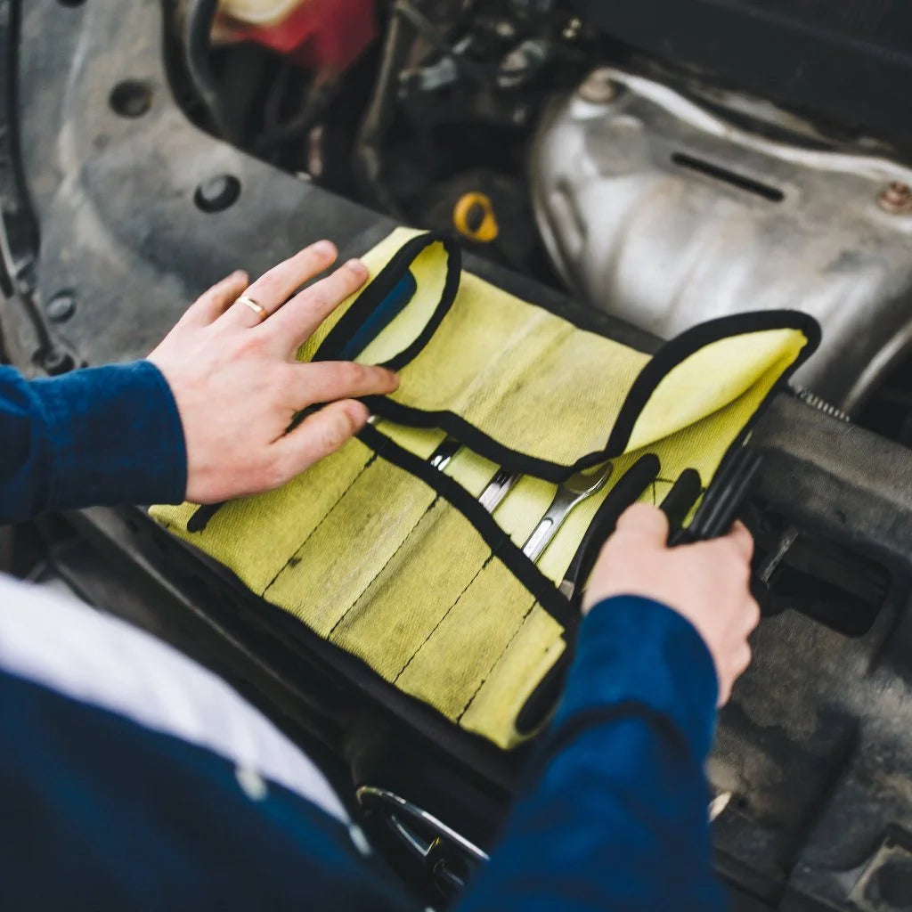Vintage Yellow Fire Hose Tool Roll from Recycled Firefighter, showcasing the unique scuffs and character of real retired fire gear. This heavy-duty roll is box-stitched at all stress points to ensure a lifetime of reliable tool storage.