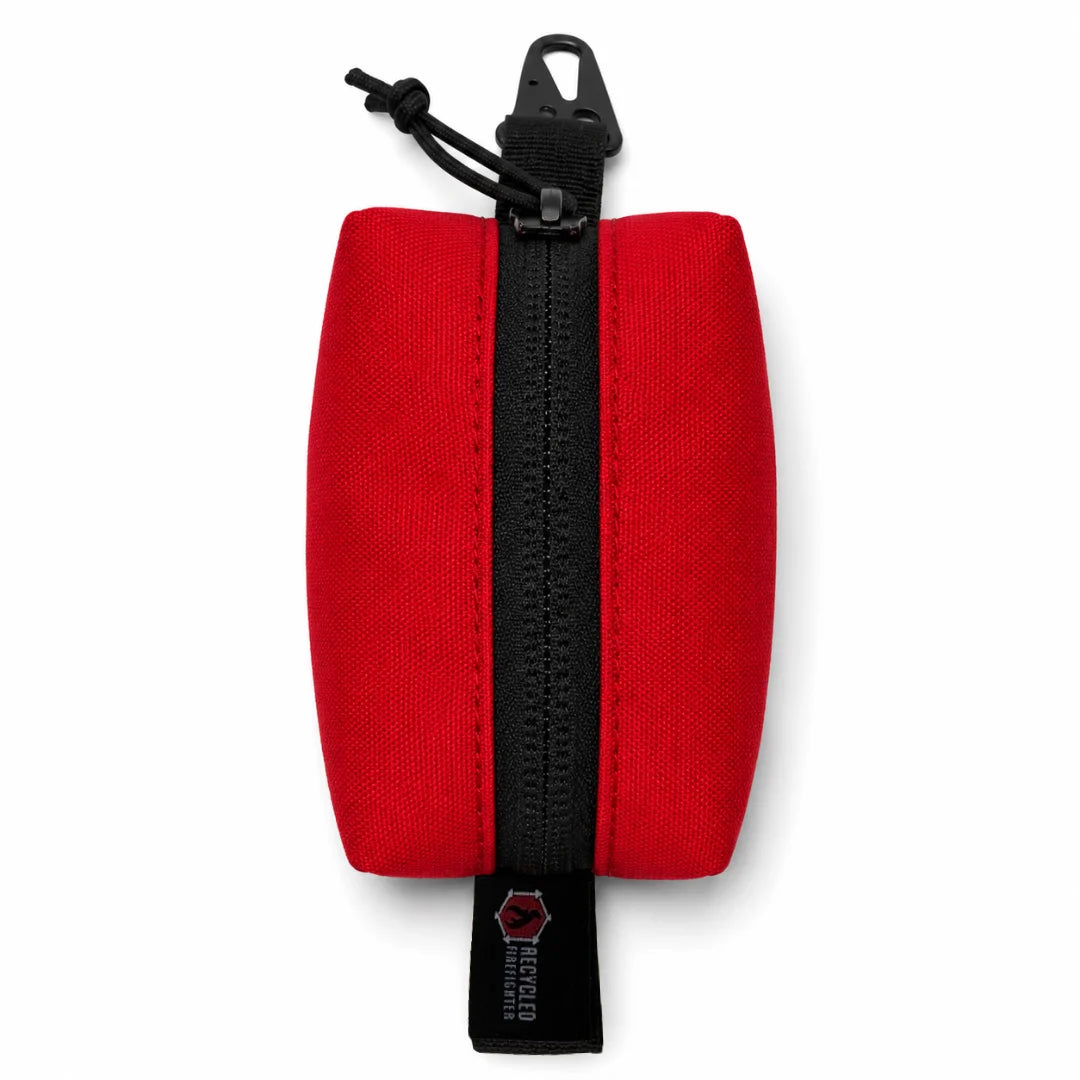 The bold Red Hot Shot Commander Keychain Pouch by Recycled Firefighter is a vibrant, fire-inspired EDC essential handcrafted in the USA for daily use. A heavy-duty zipper and metal clip make this compact organizer ready to attach to keys, belt loops, or backpack straps.