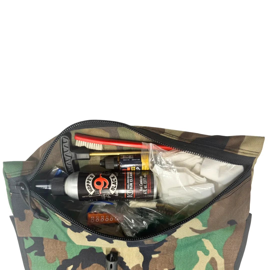 "Close-up of the built-in zipper pouch on the Recycled Firefighter Long Rifle Mat Firehose Edition in Vintage Green & Woodland. The 15 x 6.5 inch YKK-zippered pouch keeps cleaning tools and accessories secure at the range."