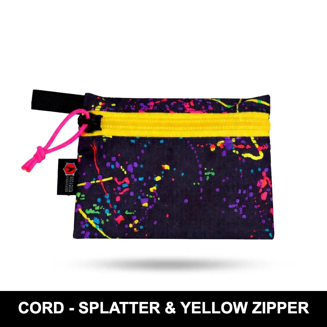 Cordura Splatter Truckie Medium by Recycled Firefighter pouch with a bright yellow zipper, rugged fabric, and compact storage for organizing everyday gear.