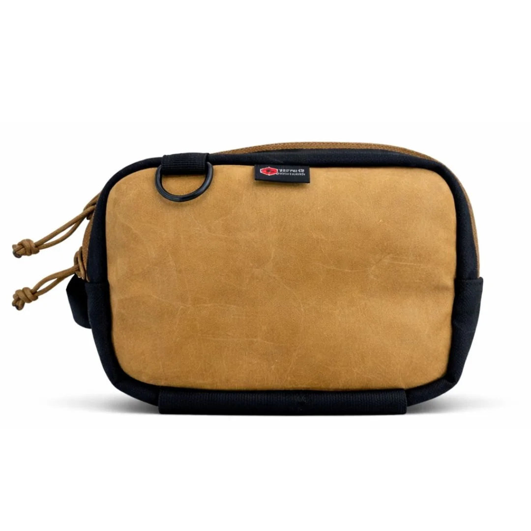 A Recycled Firefighter Trailhound fanny pack in Vintage Red firehose material. The fabric shows a weathered, authentic distress from years of service, featuring a matte red finish with a black zipper, black adjustable strap, and a side brass grommet for dog bags.