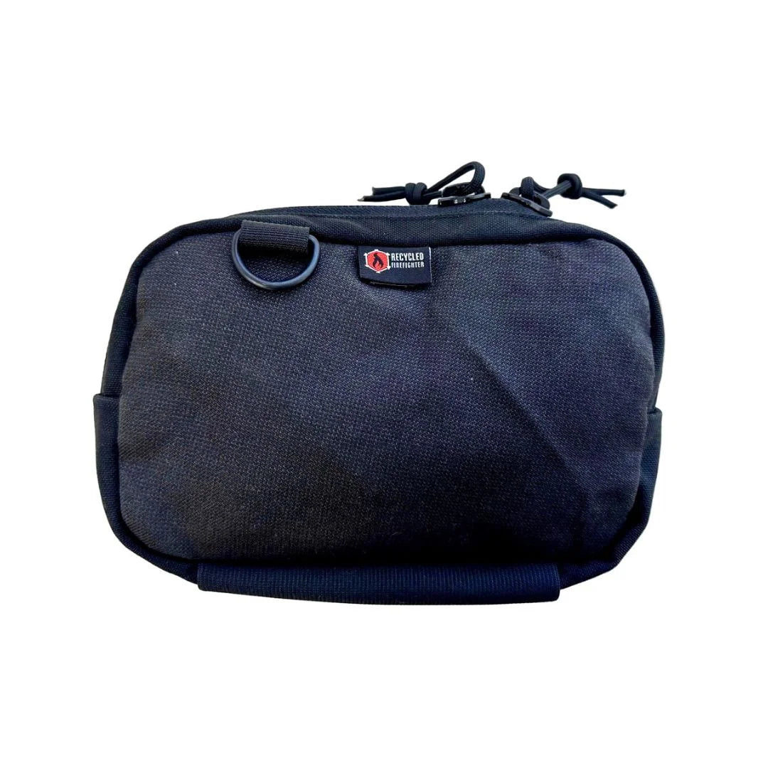 Recycled Firefighter Trailhound pack in all-black MSA bunker gear. The fabric has a distinct ripstop grid texture and a matte finish, paired with black hardware for a sleek, monochromatic tactical appearance.