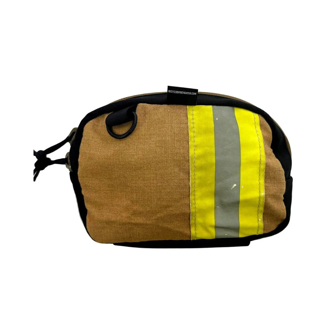 Recycled Firefighter Trailhound fanny pack in tan/brown bunker gear, featuring a vertical yellow and silver reflective safety stripe on the left side. The rugged upcycled fabric shows unique wear patterns from its previous life in the fire service.
