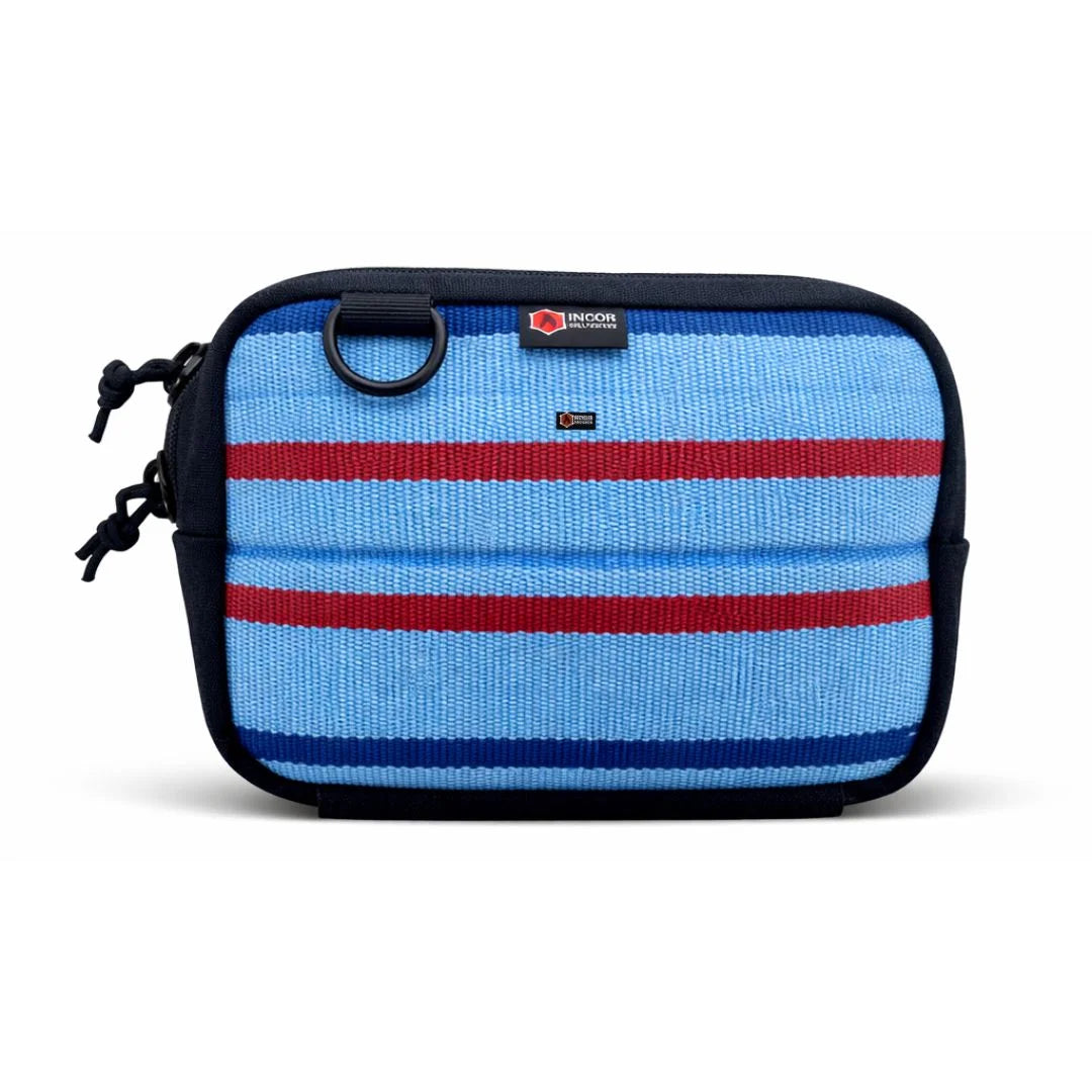 The Recycled Firefighter Trailhound pack in Ocean Breeze firehose, featuring a bright turquoise or teal hue. The rugged upcycled fabric is accented with black zippers and a bottom elastic pouch for securing extra gear.