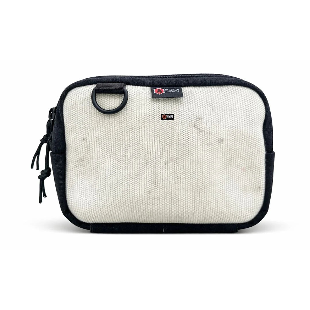 Recycled Firefighter fanny pack in Vintage White firehose. The off-white material has a rugged, industrial texture with subtle gray markings from its former life. It includes a 55-inch black adjustable waist strap and a side-mounted brass grommet.